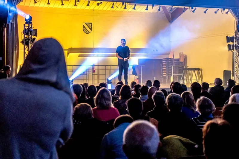 Le spectacle d'hypnose vu depuis la salle : R'Key seul sur scène sous les projecteurs, devant le public